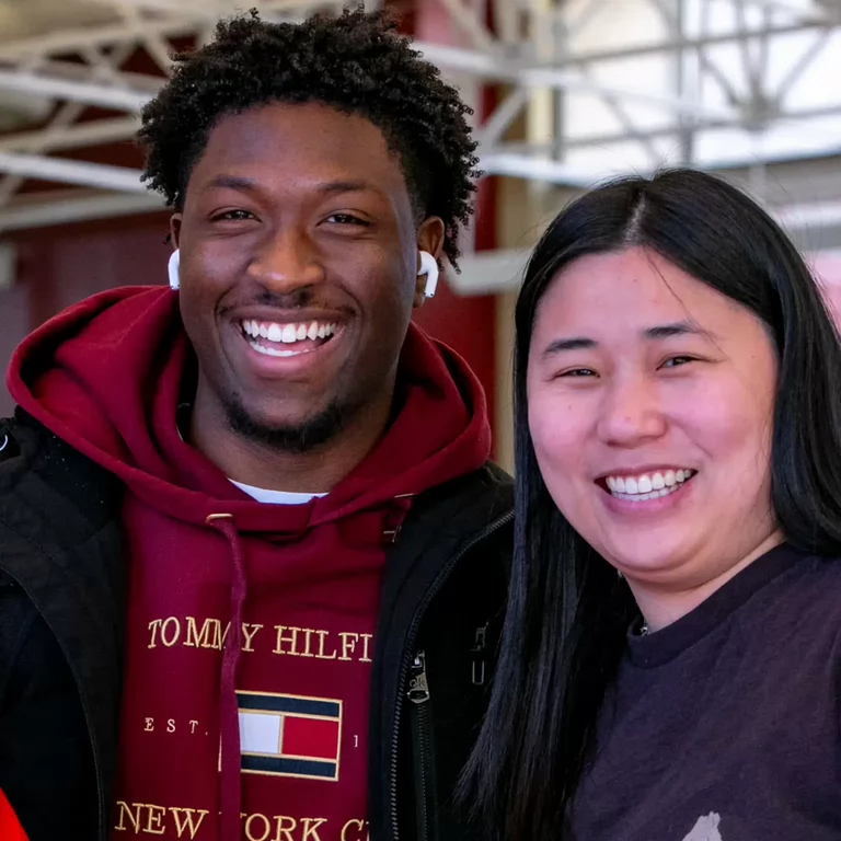 A man and a woman smile at the camera.