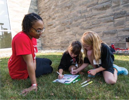 Student sitting with children