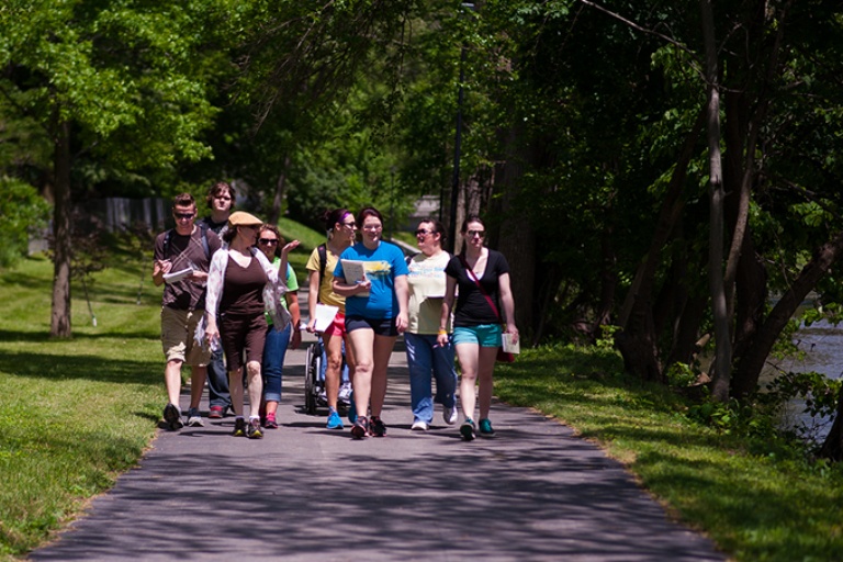 A group of students walking on campus in the summer
