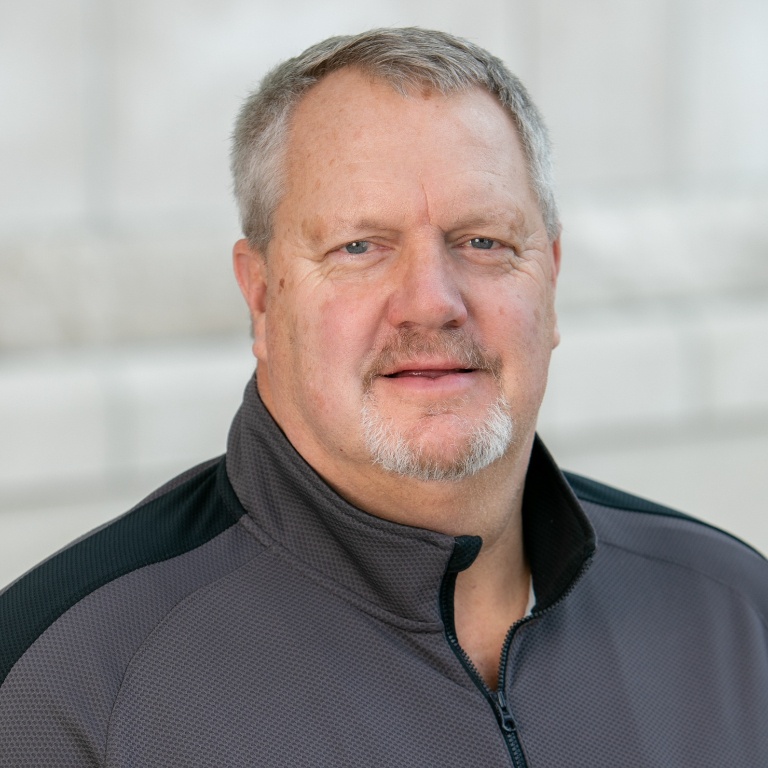 Headshot of John Sarber in a gray pullover.
